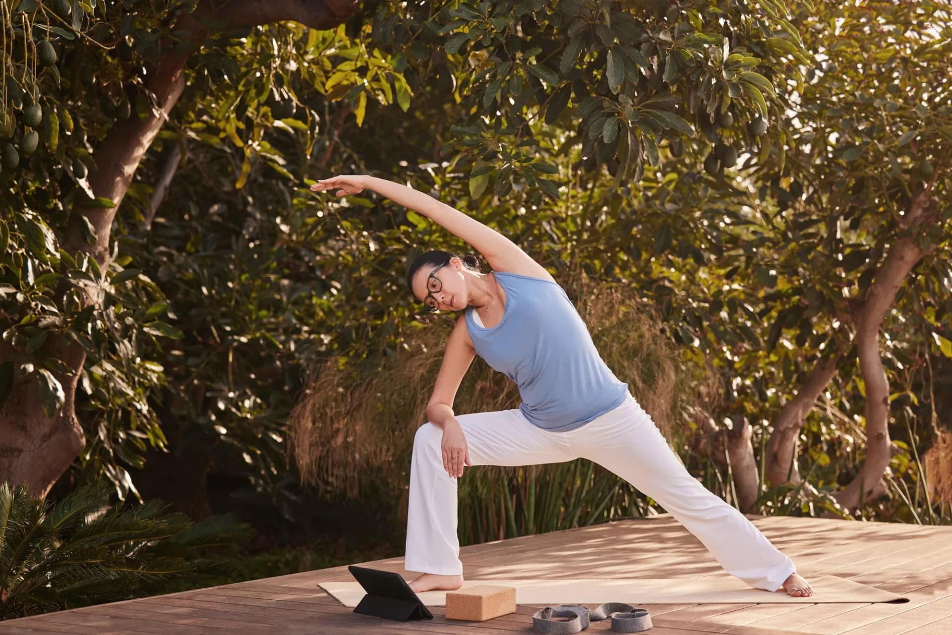 Essilor Varilux Comfort Max Transitions Gen S / Xtractive NG Lenses, Essilor Varilux Comfort Max photo of a woman in glasses doing a yoga stretch outdoors