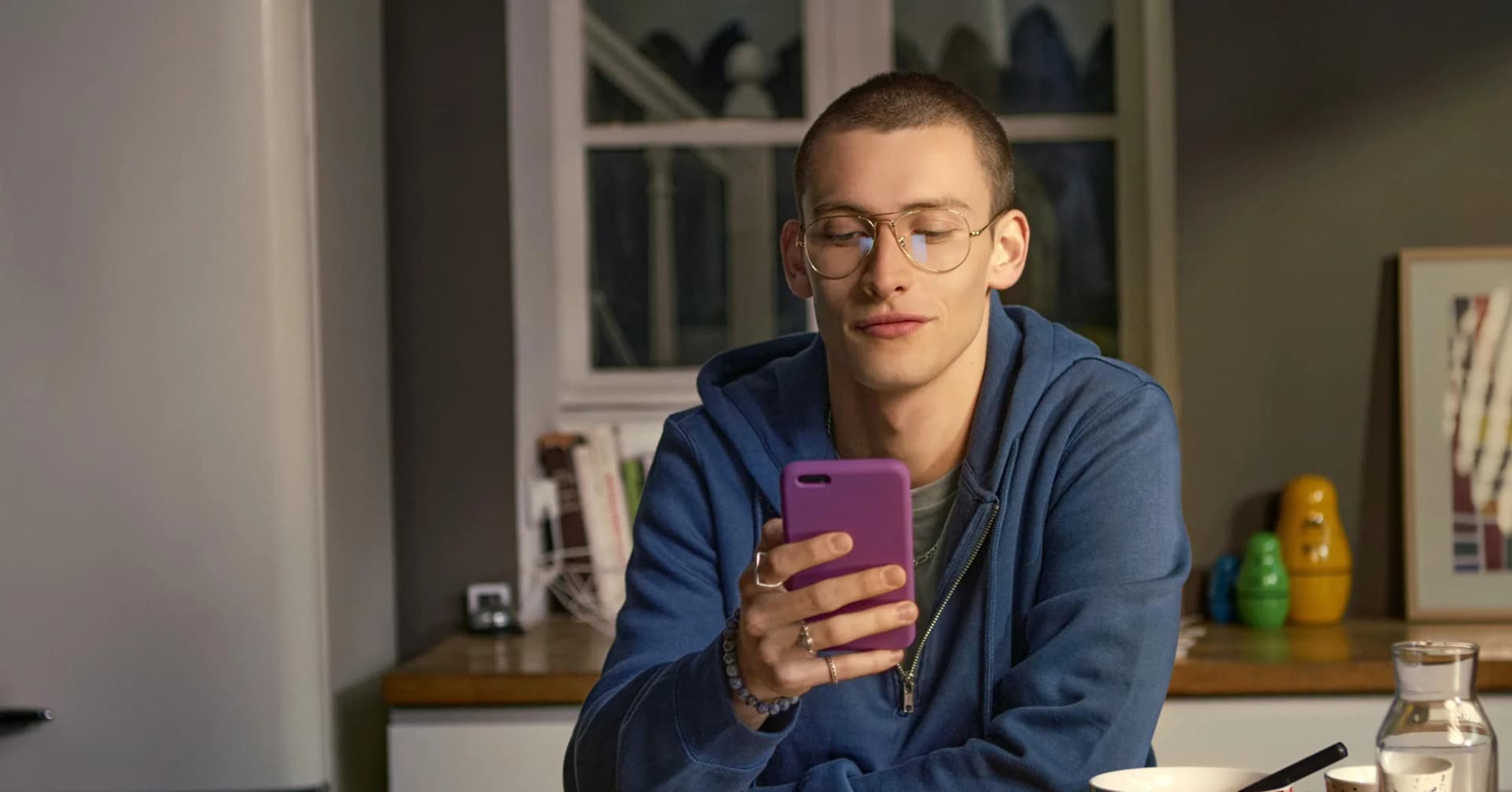 Essilor Eyezen Boost 0.4 Blue UV Capture Lenses, young man wearing spectacles while reading his smartphone