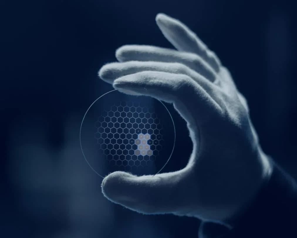 Essilor Varilux XR track Lenses, gloved hand holding a Varilux XR series lens with a hexagonal pattern overlay